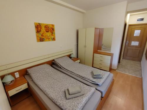 two beds in a small room with a mirror at Sunny Studio Eagle Rock in Beli Iskar