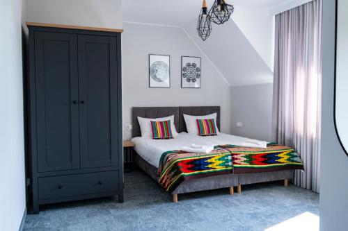 a bedroom with a bed and a cabinet in it at Stara Kuźnia in Łuków