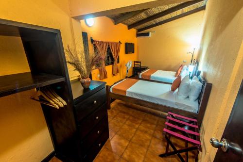 a bedroom with two beds and a dresser in a room at Hotel El Maltese in Granada