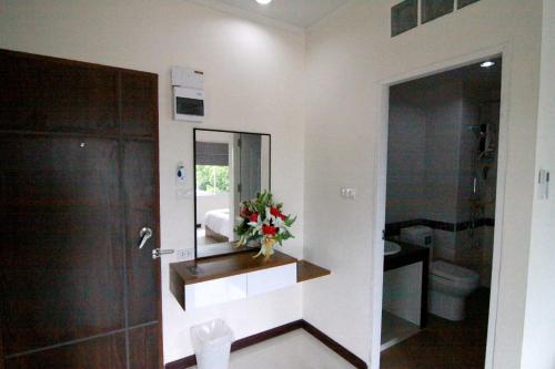 a bathroom with a sink and a mirror and a toilet at TTT Hotel in Hat Yai