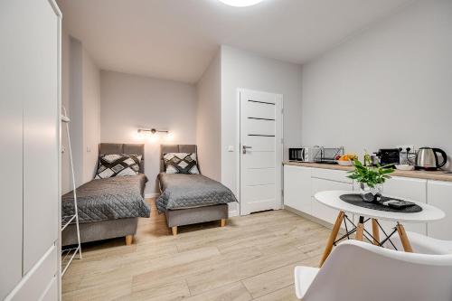 a small room with two beds and a table at Central Platinum Apartments 25 Studio z aneksem kuchennym i tarasem in Rybnik