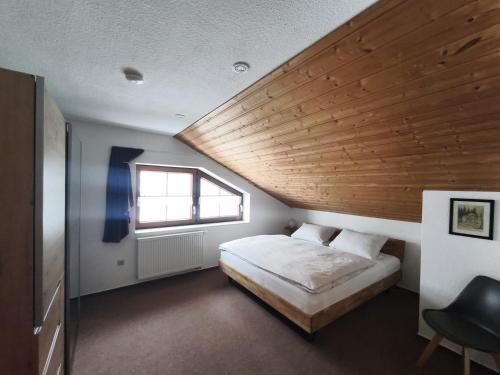 a bedroom with a bed and a wooden ceiling at Ferienwohnung Katrin Spindler in Ilmenau