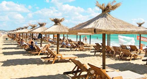 a group of chairs and umbrellas on a beach at Elias Apartment in Golden Sands