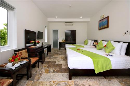 a hotel room with two beds and a couch at Lucky Leaf Hoian Villa in Hoi An
