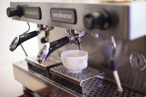 a coffee maker is pouring coffee into a cup at Orussey One Hotel & Apartment in Phnom Penh