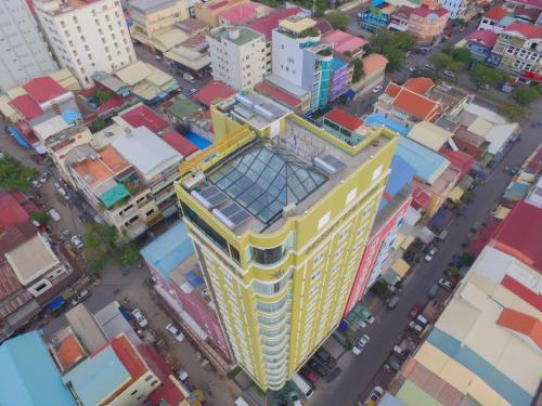 eine Aussicht auf ein hohes gelbes Gebäude in einer Stadt in der Unterkunft Orussey One Hotel & Apartment in Phnom Penh
