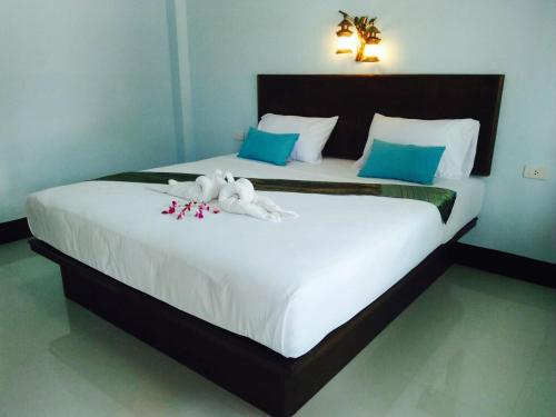 a bedroom with a large bed with two stuffed animals on it at Zam Zam House in Ko Lanta