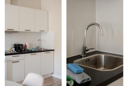 a kitchen with white cabinets and a sink at Comfortable 1-Bedroom Flat in Central Rotterdam in Rotterdam