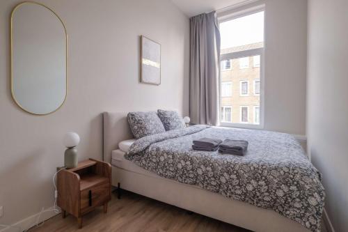 a bedroom with a bed and a large window at Comfortable 1-Bedroom Flat in Central Rotterdam in Rotterdam