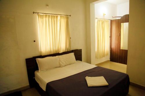 a bedroom with a bed with a towel on it at Avalan Resort Homestay in Thekkady