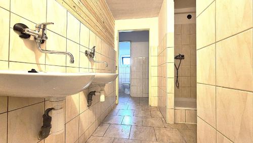 a bathroom with two sinks and a hallway at Hotel Habsburg in České Hamry