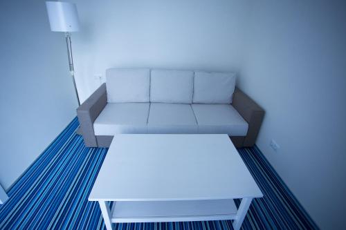 a living room with a couch and a coffee table at Aparthotel Tangerine in Batumi