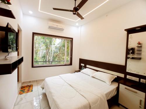 a bedroom with a large bed and a window at Chikkary's Inn in Munnar