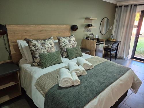 a bedroom with a large bed with towels on it at Sage Haven Guesthouse in Modimolle