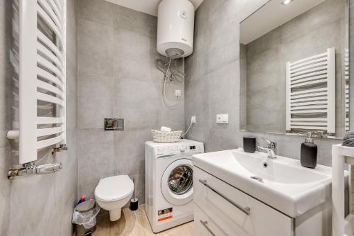 a bathroom with a washing machine and a sink at Central Platinum Apartments 30 Studio z aneksem kuchennym in Rybnik