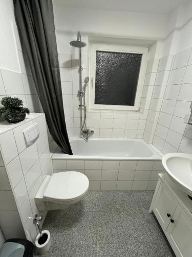 a bathroom with a toilet and a tub and a sink at City Apartment Schillerstraße in Wilhelmshaven