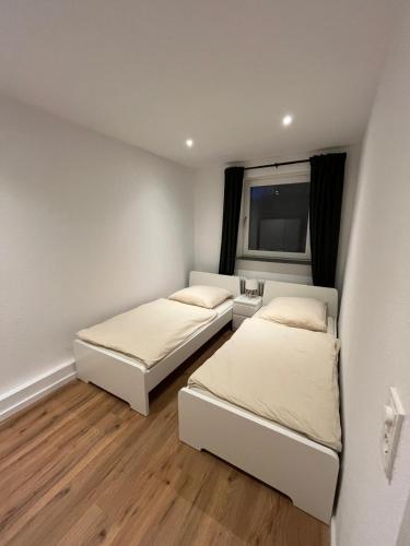 a bedroom with two beds and a window at City Apartment Schillerstraße in Wilhelmshaven
