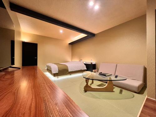 a living room with a couch and a bed at HOTEL ZEN-Adult Only in Hirosaki