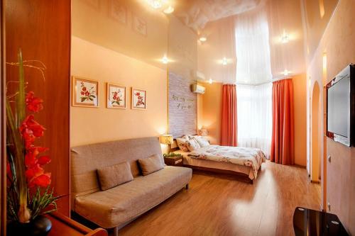 エカテリンブルクにあるApartment GreenHouse at Bazhovaのベッドルーム(ベッド1台、ソファ、テレビ付)