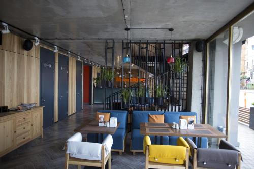 a restaurant with a blue couch and tables and chairs at Aparthotel Tangerine in Batumi
