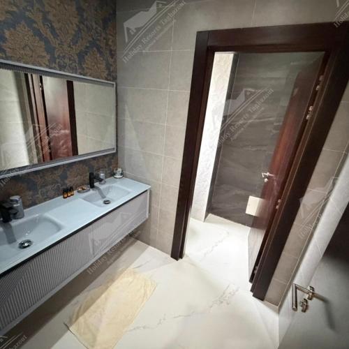 a bathroom with a sink and a mirror and a shower at Serenity Sea Villa Taghazout Bay Amda in Taghazout