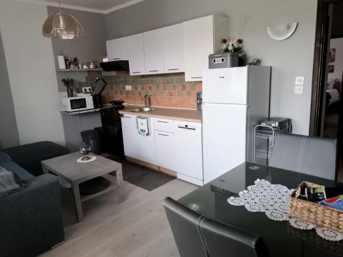 a kitchen with white cabinets and a table in a room at Apartma Xanadu in Slovenske Konjice