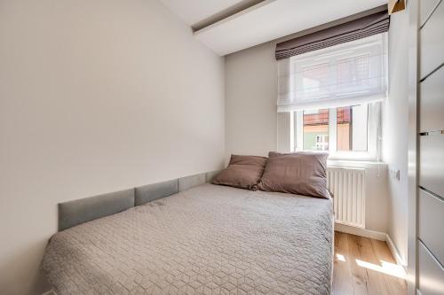 a small bedroom with a bed and a window at Central Platinum Apartments 15 in Rybnik