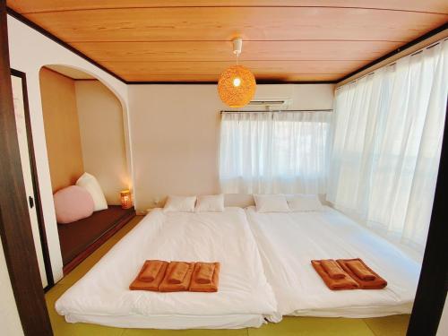 a bedroom with a large white bed in front of a window at Wamodannooyado Yaguchinowatashi in Tokyo