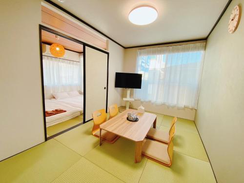a room with a table and chairs and a bedroom at Wamodannooyado Yaguchinowatashi in Tokyo