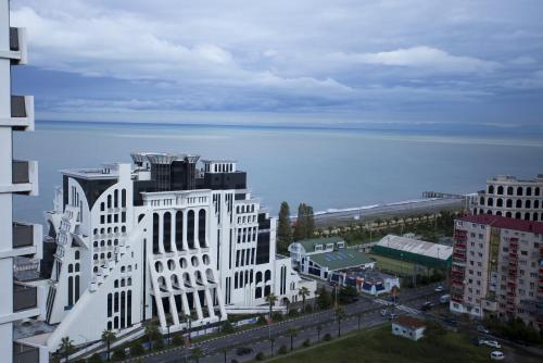 a large white building in front of the water at Aparthotel Tangerine in Batumi