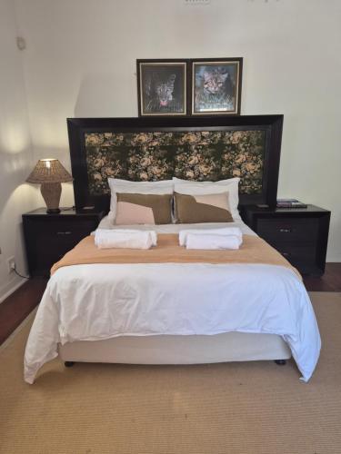 a bedroom with a large bed with two night stands at Open plan apartment in Muizenberg in Muizenberg