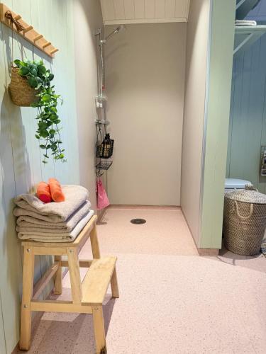 a shower room with a pile of towels on a stool at Cabin in Tappeluft in Alta