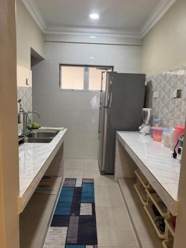 a kitchen with a refrigerator and a sink at Puchong Permata Homestay 3BR in Puchong