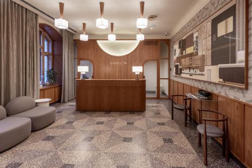 a hotel lobby with a reception desk and chairs at Carillon Aparthotel - Keystone Collection, opened December 2025 in Riga