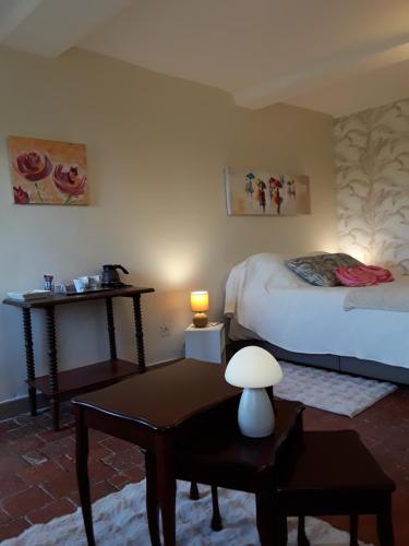 a bedroom with two beds and a table with a lamp at La Guerandelle in Ernes