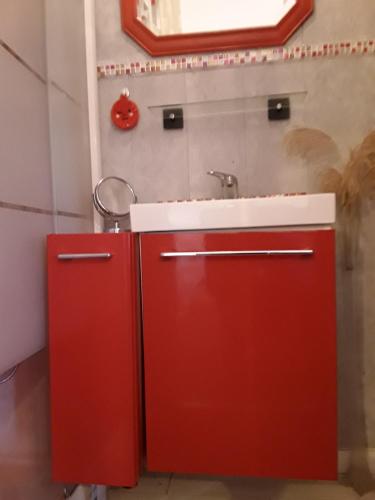 a red kitchen with a sink and a red refrigerator at La Guerandelle in Ernes