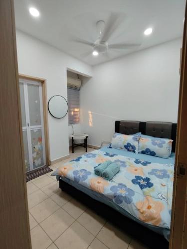 a bedroom with a large bed with blue flowers on it at Puchong Permata Homestay 3BR in Puchong