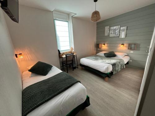 a hotel room with two beds and a table at Le Relax in Boulazac