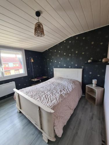 a bedroom with a large bed in a room at Les malices d'Ulysse in Péronne