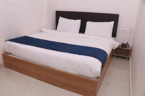 a bedroom with a large bed with a wooden frame at Hotel Lakhdatar in Kota