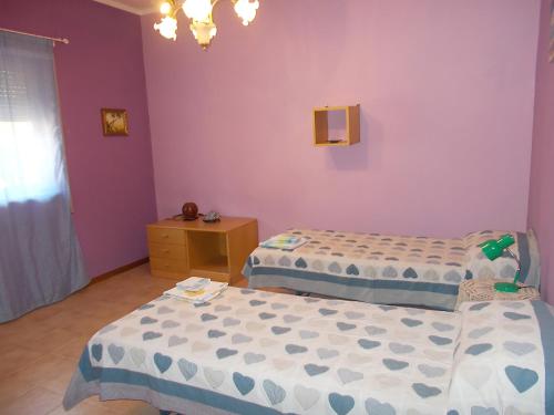 two beds in a room with purple walls at Casa Vacanze Beppe in Termini Imerese