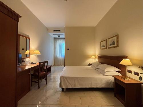 ein Schlafzimmer mit Bett, Schreibtisch und Computer in der Unterkunft Naples Park Hotel in Marigliano