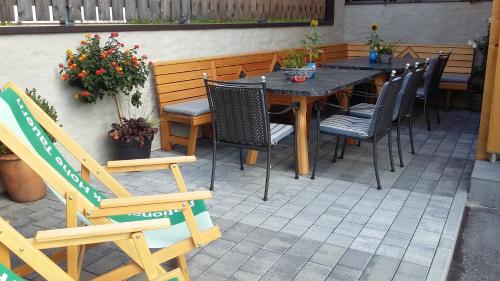 a wooden table and chairs on a patio at Ferienhaus Sonnenhang in Matrei in Osttirol