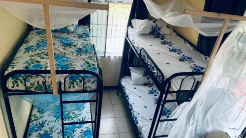 two bunk beds are in a room with a window at Agape hostel in Bagamoyo