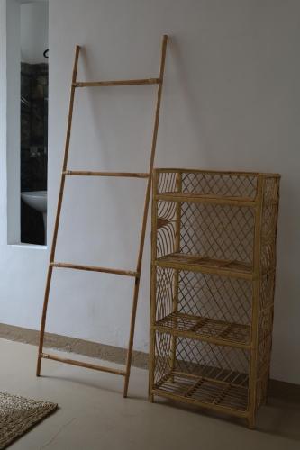 a wooden book shelf sitting next to a wall at Papaya Tree Hostel in Weligama