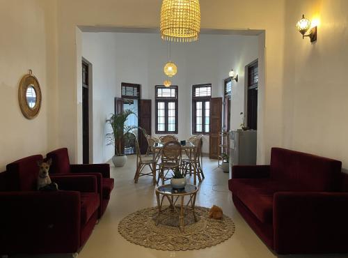 a living room with red couches and a table at Papaya Tree Hostel in Weligama