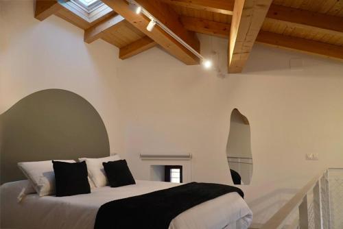 a bedroom with a large bed with black and white pillows at A Bolota, Casa rural in Trevejo