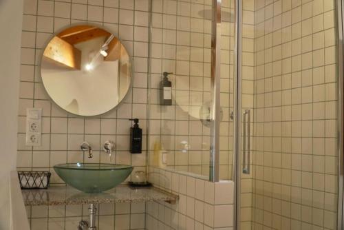a bathroom with a green sink and a mirror at A Bolota, Casa rural in Trevejo