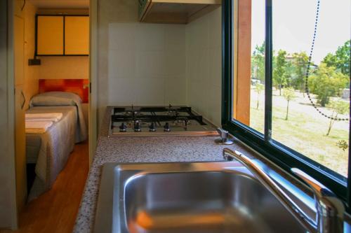a kitchen with a sink and a window next to a bed at Agriturismo San Gregorio in San Vincenzo