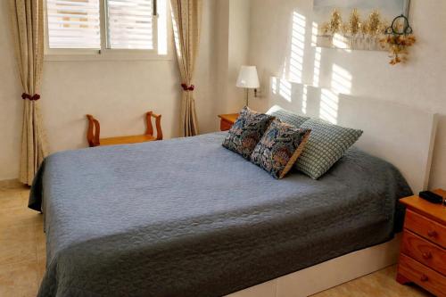 a bedroom with a bed and a chair and windows at SOLMAR La Mata Beach in Torrevieja